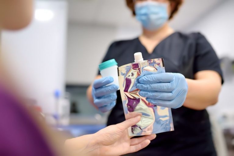 Zdravotná sestra v laboratóriu ponúka pacientovi lekársky balón na nafúknutie, aby vykonal test na Helicobacter.