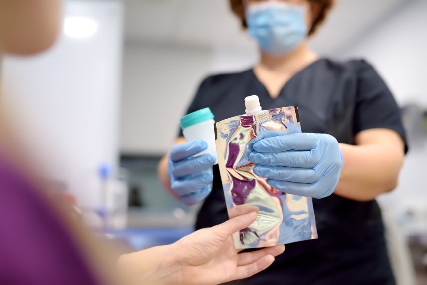 Zdravotná sestra v laboratóriu ponúka pacientovi lekársky balón na nafúknutie, aby vykonal test na Helicobacter.