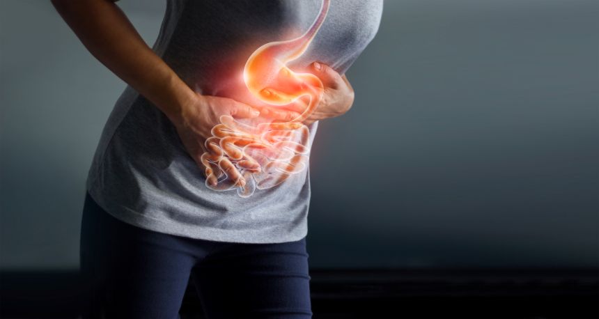 Žena sa dotýka bolestivého žalúdka, ktorá je príčinou, žalúdočného vredu, zápalu slepého čreva alebo ochorenia gastrointestinálneho systému.